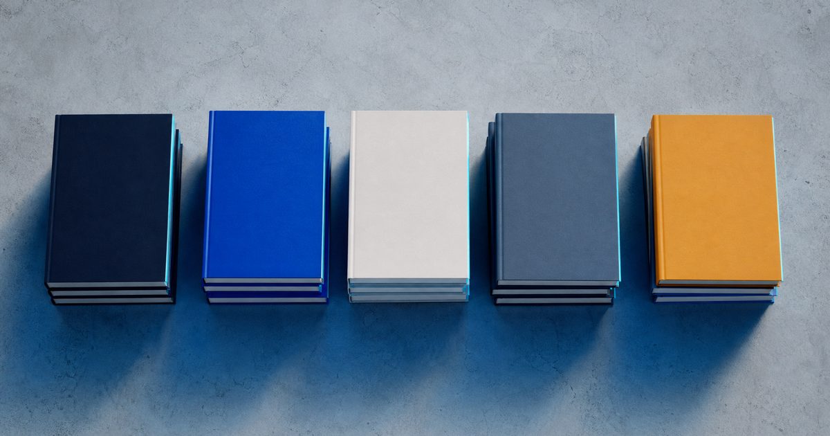 Five stacks of paperbacks side by side on a light table, seen from above